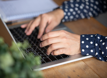 Student typing at a laptop